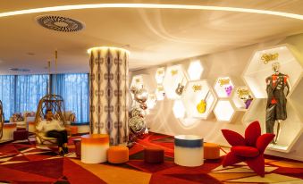 a modern living room with a unique design , including a red and orange carpet , multiple seating arrangements , and decorative objects at Hard Rock Hotel Ibiza