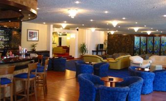 a large , well - lit hotel lobby with multiple couches and chairs , creating a comfortable seating area at Park