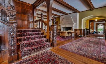 a grand staircase with red and blue carpet , leading to the second floor of a house at Inn at Villanova University