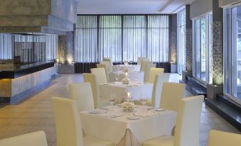 a well - decorated dining room with white tablecloths , chairs , and candles set for a formal event at Thistle Port Dickson Resort