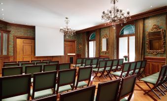 a large conference room with rows of chairs arranged in a semicircle , and a podium at the front of the room at Hotel d'Angleterre