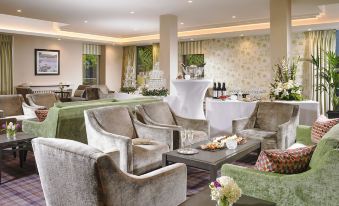 a well - decorated hotel lobby with several chairs and couches arranged for guests to relax and socialize at Actons Hotel Kinsale
