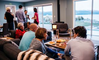 a group of people are sitting on couches in a room , enjoying food and conversation at Lakestone Lodge