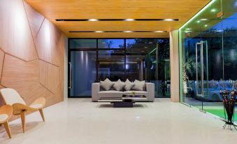 The modern-looking living area features large windows and furniture at The Zense Boutique Hotel