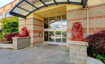 a building entrance with two red lions on either side of the door , creating an impressive entrance to the building at Red Lion Inn and Suites Victoria