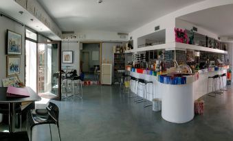 a modern cafe with white walls , gray floors , and various beverages on display , including wine glasses and bottles at Hotel Astoria