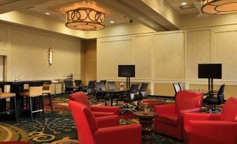 a large , well - lit room with multiple couches and chairs arranged in various seating options , creating an inviting atmosphere for socializing at Tysons Corner Marriott