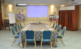 a conference room set up for a meeting , with chairs arranged in a circle around a long table at Hotel Marina