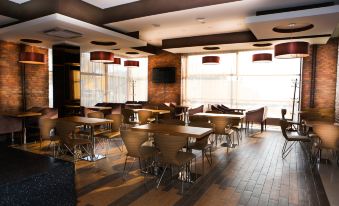 a modern restaurant with wooden floors and ceiling , featuring several tables and chairs arranged for guests at Park Hotel