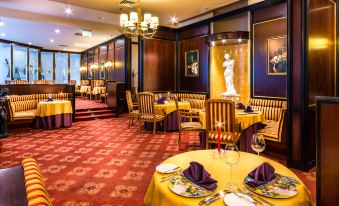 a dining room with a table set for a formal dinner , featuring a yellow tablecloth and chairs at Radisson Blu Hotel, Szczecin