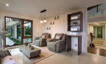 a living room with two couches , a coffee table , and bookshelves filled with books and other items at Koanze Luxury Hotel & Spa