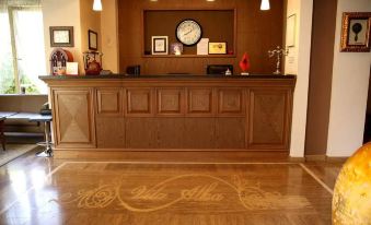 a reception area with a wooden desk and chairs , as well as a clock on the wall at Oxford Hotel