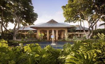 a large building with a fountain in front of it , surrounded by lush greenery and trees at Four Seasons Resort Lana'i