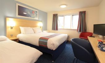 a hotel room with three beds , two of which are twin beds and one is a double bed at Travelodge St. Clears Carmarthen