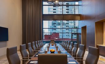 a long conference table with chairs , large windows , and a cityscape view in the background at Hyatt Regency Seattle
