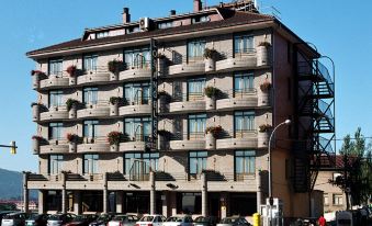 a large building with multiple balconies and air conditioning units is surrounded by parked cars on a street at Hotel Los Angeles