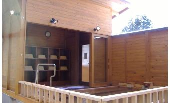 a modern wooden building with a balcony and air conditioning units , providing a comfortable living space at Ganiba Onsen