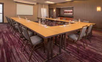 a conference room with a long table , chairs , and a projector screen set up for a meeting at Sonesta Select Columbia