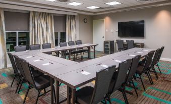 a large conference room with several rows of chairs arranged in a semicircle , and a tv mounted on the wall at Residence Inn Waynesboro