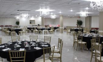 a large banquet hall filled with tables and chairs , ready for a formal event or wedding reception at Holiday Inn Hazlet