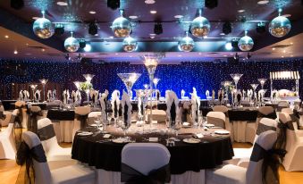 a beautifully decorated banquet hall with multiple tables set for a formal event , including wine glasses and centerpieces at Holiday Inn Aberdeen - West
