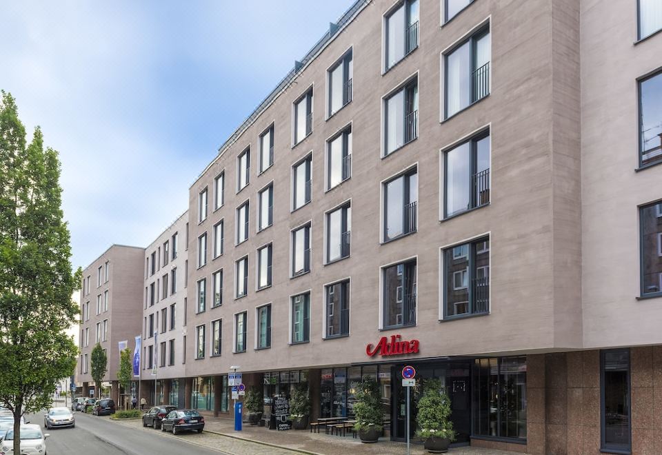 a city street with a tall building on the left side and a smaller building on the right side at Adina Apartment Hotel Nuremberg