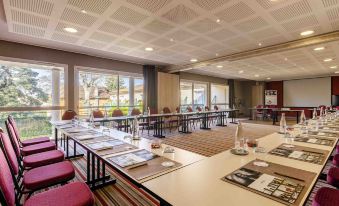 a conference room set up for a meeting , with chairs arranged in a semicircle around a long table at Mercure Castres l'Occitan