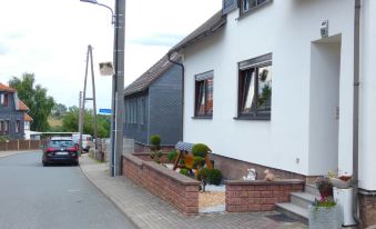 a brick house with a red brick wall and two windows is located on a street corner at Petra