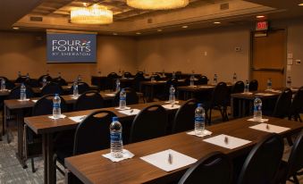 "a conference room set up for a meeting , with chairs arranged in rows and a projector displaying the word "" four points ""." at Four Points by Sheraton Allentown Lehigh Valley