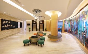 a modern hotel lobby with marble floors , a large reception desk , and a seating area at Hotel Ciputra Cibubur Managed by Swiss-Belhotel International