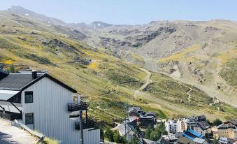 a mountainous landscape with a small town nestled in the valley , surrounded by grass - covered hills at Bellevue