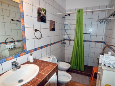a bathroom with a toilet , sink , and bathtub , as well as a shower and toilet at Titi Titi Photo