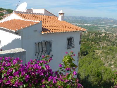 a house with a red tile roof and a view of the valley from a balcony at Joli Joli Photo