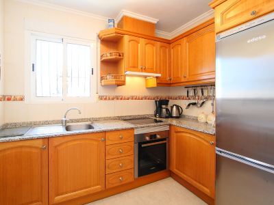 a modern kitchen with wooden cabinets , stainless steel appliances , and a black dishwasher , all under the shade of sunlight at Joli Joli Photo
