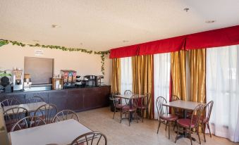 a dining room with tables and chairs arranged for a group of people to enjoy a meal together at Executive Inn