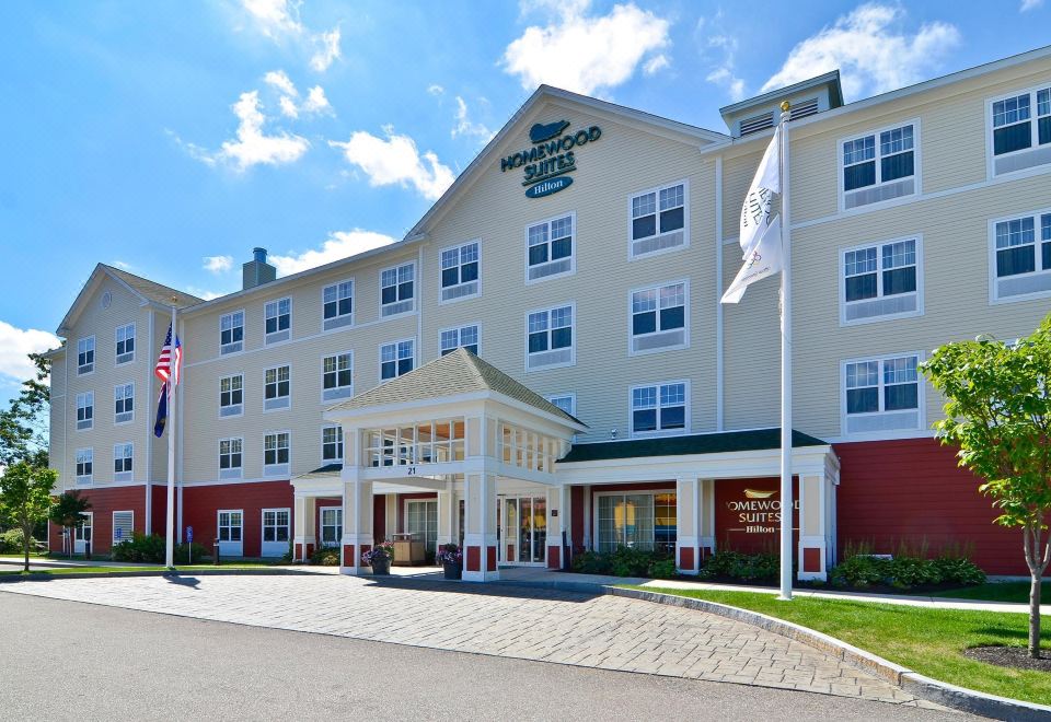 a large hotel with a white and red color scheme , featuring a flag on the front at Homewood Suites by Hilton Dover