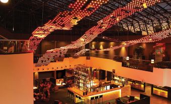 a modern restaurant with an open kitchen and a bar area , illuminated by red lights at Mercure Sydney Bankstown