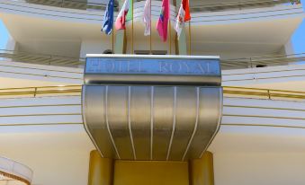 "a large hotel entrance with multiple flags on top and a sign reading "" the ocean hotel "" above the door" at Hotel Royal