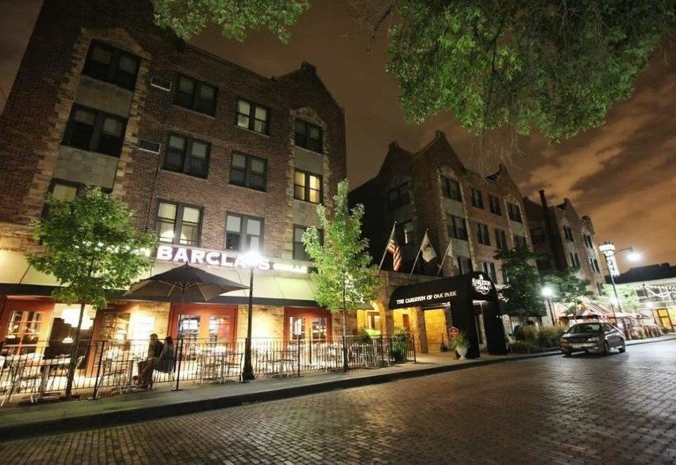 "a brick building with a sign that says "" barco "" is at night , surrounded by trees and lit up" at Carleton of Oak Park