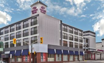 a large building with multiple floors , situated on a city street corner under a cloudy sky at Crowne Plaza Kitchener-Waterloo