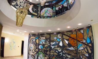 a modern interior with a unique curved glass wall and large windows , decorated with colorful stained glass panels at Greenberg