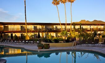 a large hotel with a swimming pool and palm trees is reflected in the water at Civana Wellness Resort & Spa