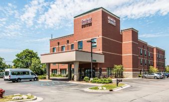 "a red brick building with a sign that reads "" comfort suites "" prominently displayed on the front of the building" at Comfort Suites