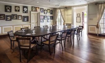 a large dining room with a long table and chairs arranged for a group of people at Strawberry Hill