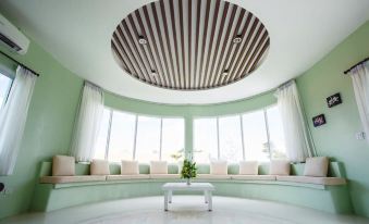 a modern , minimalist room with green walls and white furniture , featuring a circular ceiling design at The Location