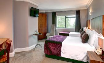 a hotel room with two beds , a television , and a window , all decorated in purple and white colors at Best Western Plus Centurion Hotel