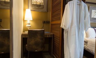 a hotel room with a bed , a desk , and a white robe hanging in the window at Z Hotel