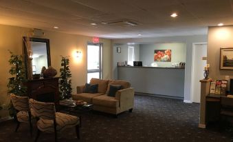 a well - lit waiting room with a couch , chairs , and a christmas tree in the background at Fairway Inn