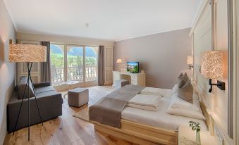 a large bedroom with a king - sized bed , hardwood floors , and a television mounted on the wall at Majestic Hotel & Spa Resort