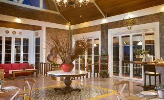 a large room with a round table , chairs , and a chandelier is decorated for the holidays at Plataran Bromo